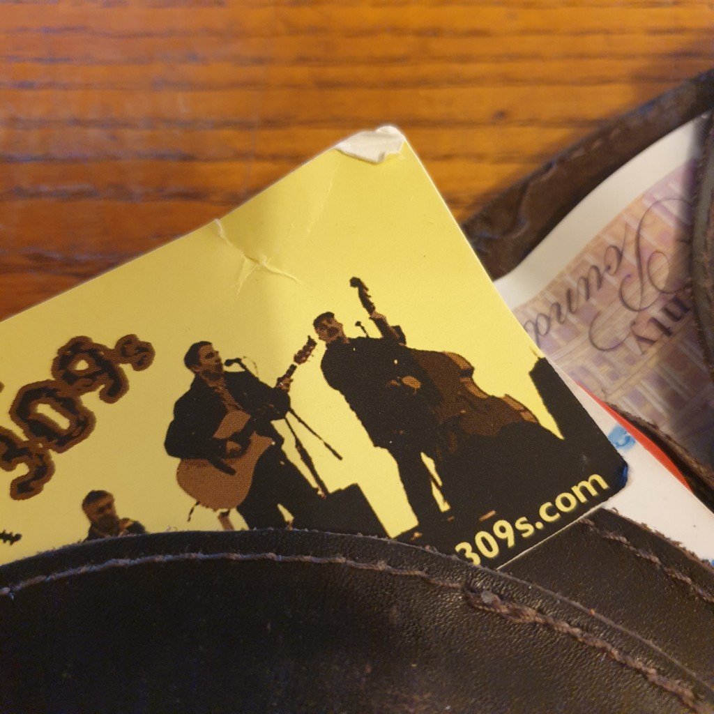 The 309s band business card, damaged from being stored in a back-pocket wallet or pocketbook